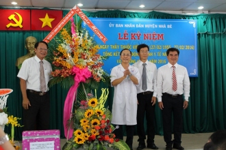 Đ/c Trần Tấn Quý - Phó Bí thư thường trực Huyện ủy trao tặng hoa chúc mừng cho các đơn vị y tế tại huyện nhân 61 năm ngày thầy thuốc Việt Nam